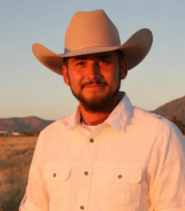 Juan Fernandez, owner of Ark Electrical, in a cowboy hat under a New Mexico sky